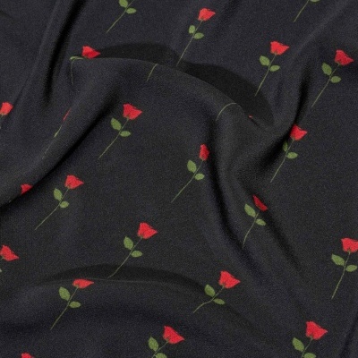 Tecido preto com padrão de pequenas rosas vermelhas e folhas verdes.