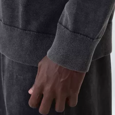 Braço com camisola cinza escuro de malha e punho canelado