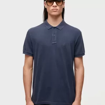 Moda masculina com polo azul escuro e óculos de sol castanhos