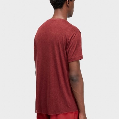 Homem de costas com t-shirt e calças vermelhas contra fundo branco