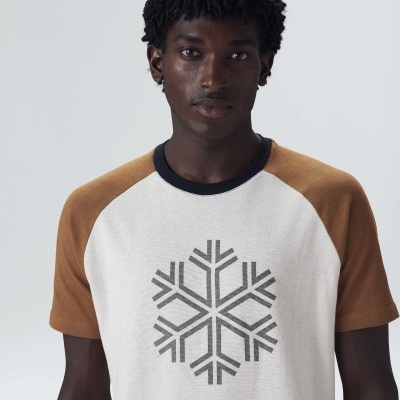 Camisola branca com mangas castanhas de manga curta e estampa de floco de neve cinza.