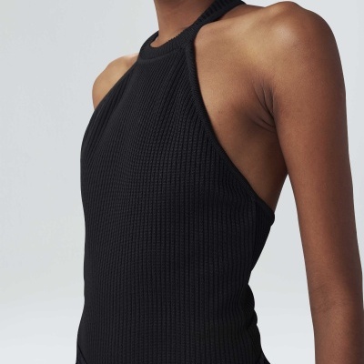 Top preto de malha canelada com decote halter em modelo feminino