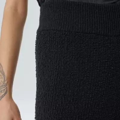 Close-up de roupa preta texturizada com cintura elástica canelada