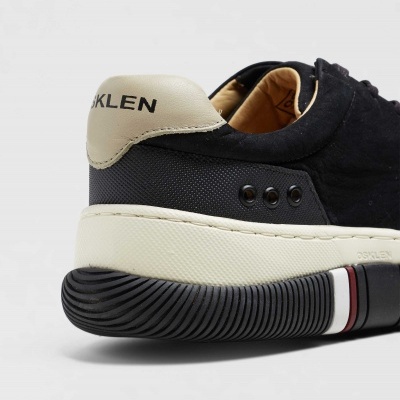 Parte traseira de ténis preto e bege com marca OSKLEN