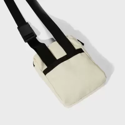 Mala pequena branca com tiras pretas e alça ajustável.