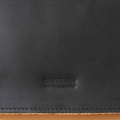 Material preto texturado em couro sintético com costura e marca OSCARLY PRO DE LHEIRO