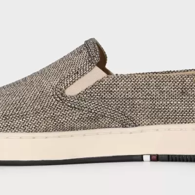 Ténis slip-on cinza e bege com sola branca e detalhes em preto e vermelho