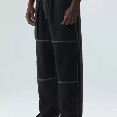 Calças pretas com costuras verdes usadas por uma pessoa