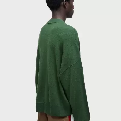 Homem de costas com camisola verde e calções castanhos listrados