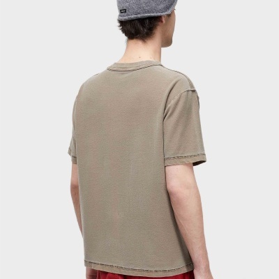 Homem de costas com gorro cinzento e t-shirt bege