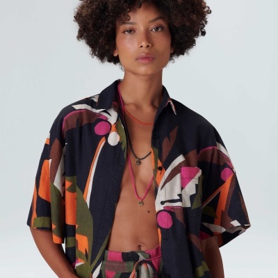 Mulher com conjunto de camisa e calças estampadas coloridas, camisa de manga curta e calças com cordão