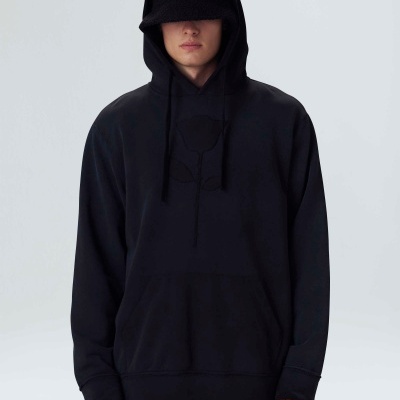 Homem usando hoodie preto com calças padrão geométrico cinza e preto