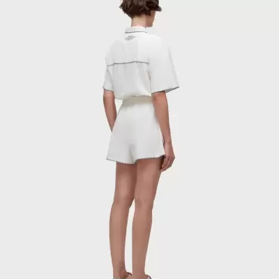 Mulher vista de costas com conjunto branco e sandálias bege