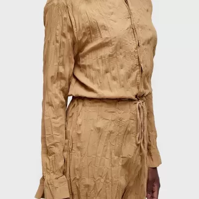 Macacão bege claro texturizado em fundo cinza