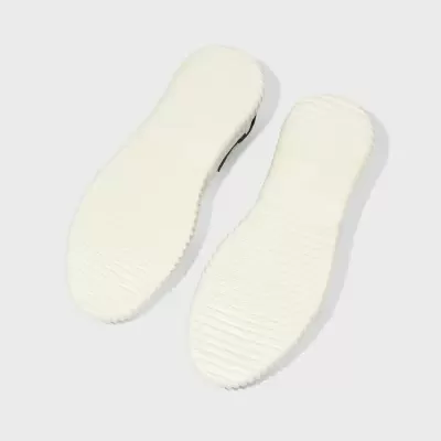 Solas de sapatos brancas com textura riscada vistas de baixo.