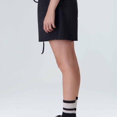 Calções pretos com bolsos grandes, meias às riscas e sapatilhas brancas