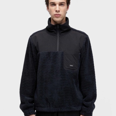 Homem jovem usando sweatshirt preta felpuda com bolso e etiqueta OBKLEN