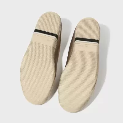 Solas de sapato bege com faixa preta e texto MADE IN SPAIN