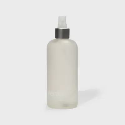 Frasco de spray cilíndrico em vidro fosco branco com tampa preta e borrifador branco