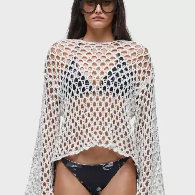 Mulher com top branco de malha aberta e óculos escuros