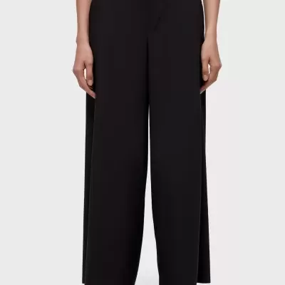 Calças pretas largas com cintura alta e ténis pretos