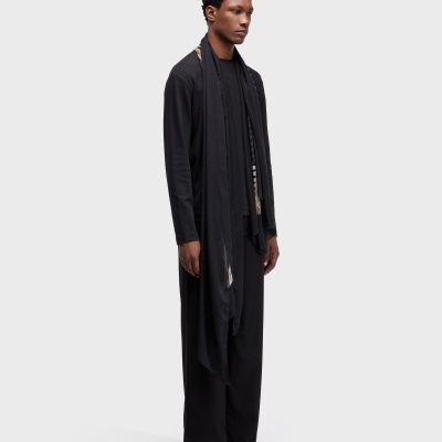 Homem com roupa preta e sandálias castanhas em fundo branco