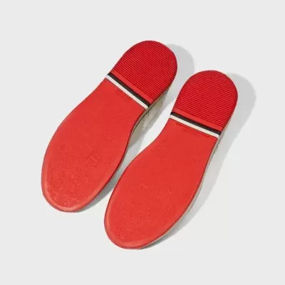 Solados vermelhos texturizados de sapatos com detalhe preto e branco