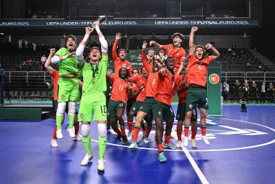 Jogadores de futsal da equipa de Portugal comemoram em campo com uniformes vermelhos e verdes no UEFA UNDER-19 FUTSAL EURO 2025.