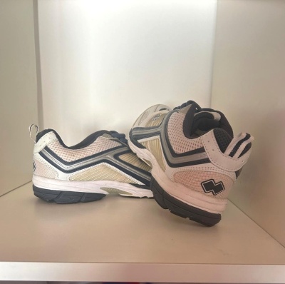 Par de sapatilhas desportivas brancas, bege e pretas em fundo branco