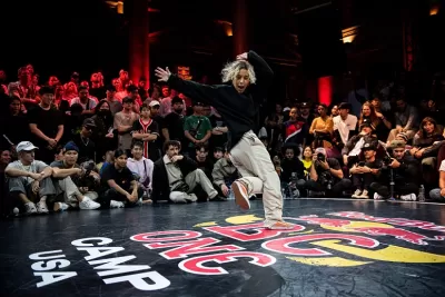 Competição de dança num palco com logótipo RED BULL BC ONE CAMP USA e público em volta