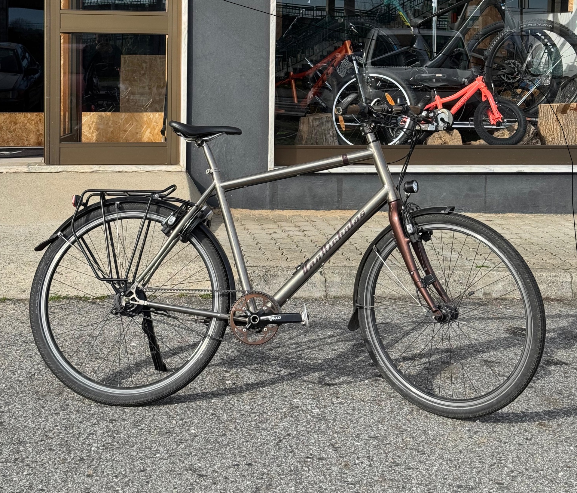 bicicleta urbana cinzenta metálica com banco preto e guarda-lamas