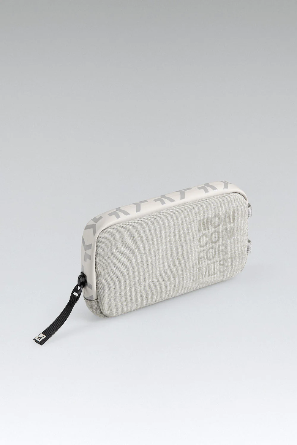 Estojo retangular cinzento claro com texto NON CONFORMIST e fecho de correr com puxador preto