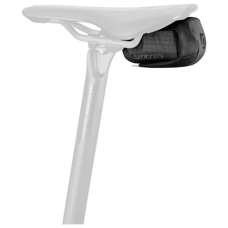 Bolsa de selim preta Syncros debaixo de selim de bicicleta branco.