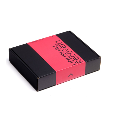 Caixa preta retangular com banda vermelha e texto 'UNUSUAL RECOVERY'