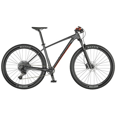 Bicicleta de montanha preta com detalhes vermelhos e pneus Maxxis.