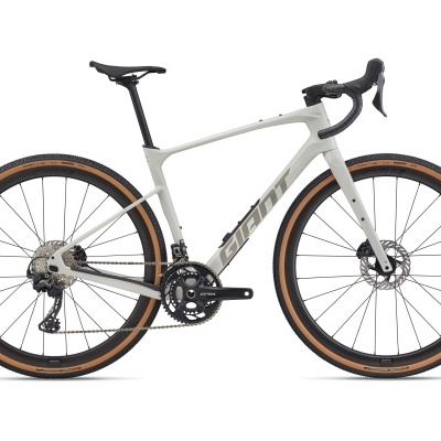 Bicicleta gravel cinzenta com pneus castanhos e componentes pretos