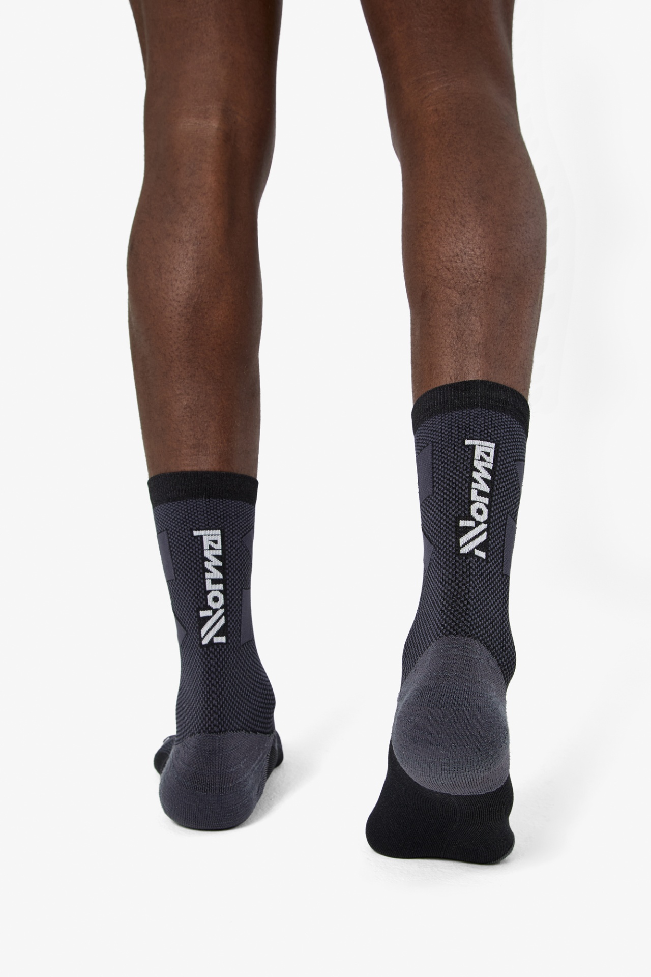 Meias pretas e cinzentas com texto Norma na parte traseira