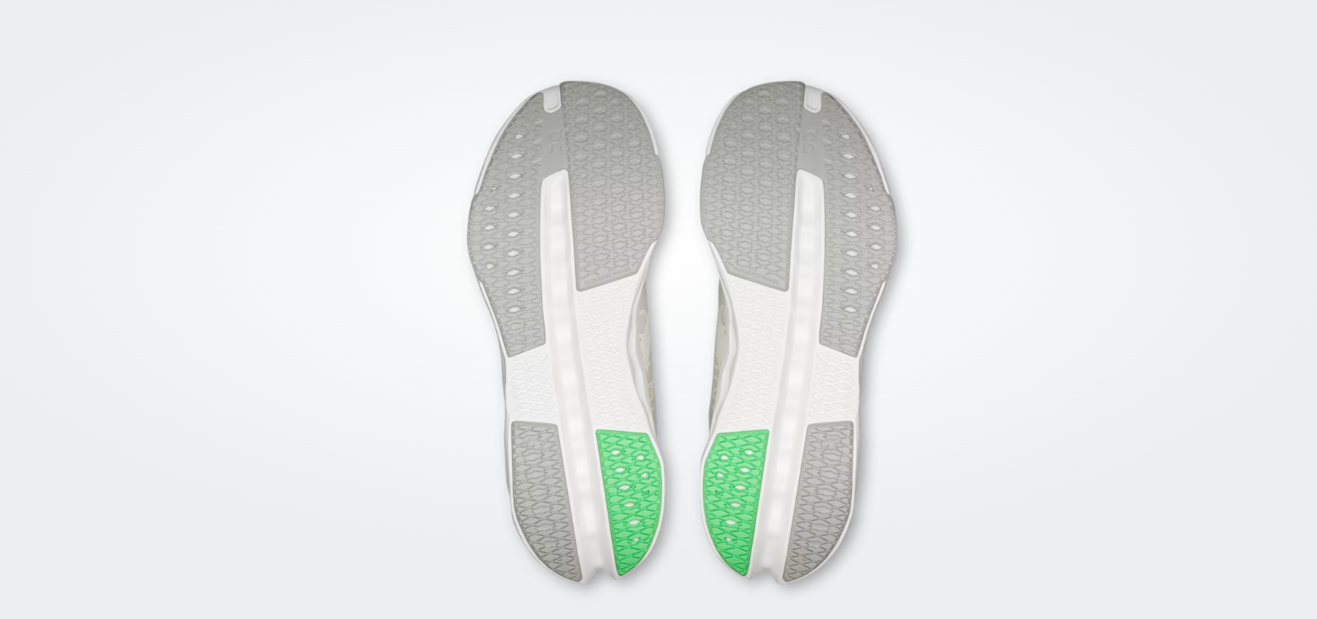 Solas de sapatilhas com padrão hexagonal cinzento, branco e verde.