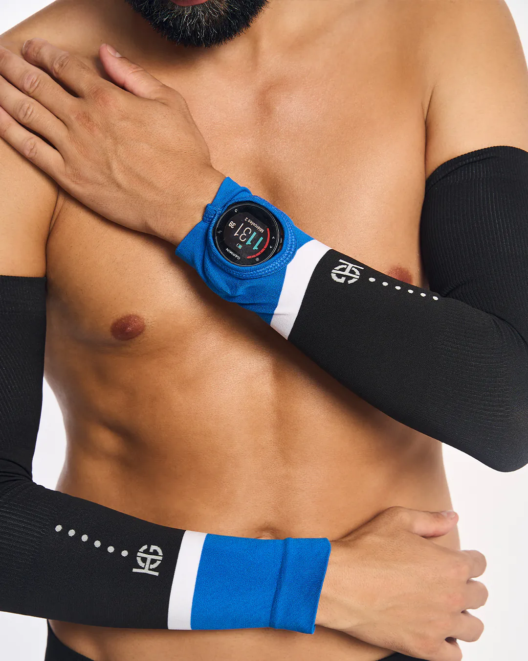 Manguitos pretos com azul e branco e logótipo branco no braço de homem com relógio Garmin