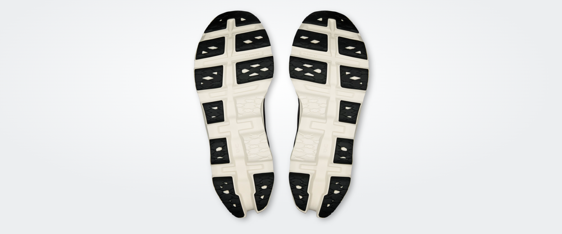 Solas de sapatilhas de corrida pretas e brancas com texto CLOUDTEC e OC.