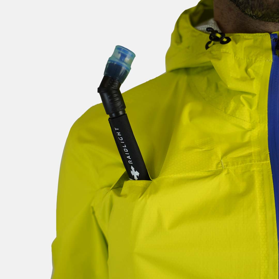 Jaqueta amarelo-escuro com fecho azul e mangueira de hidratação preta no bolso do peito