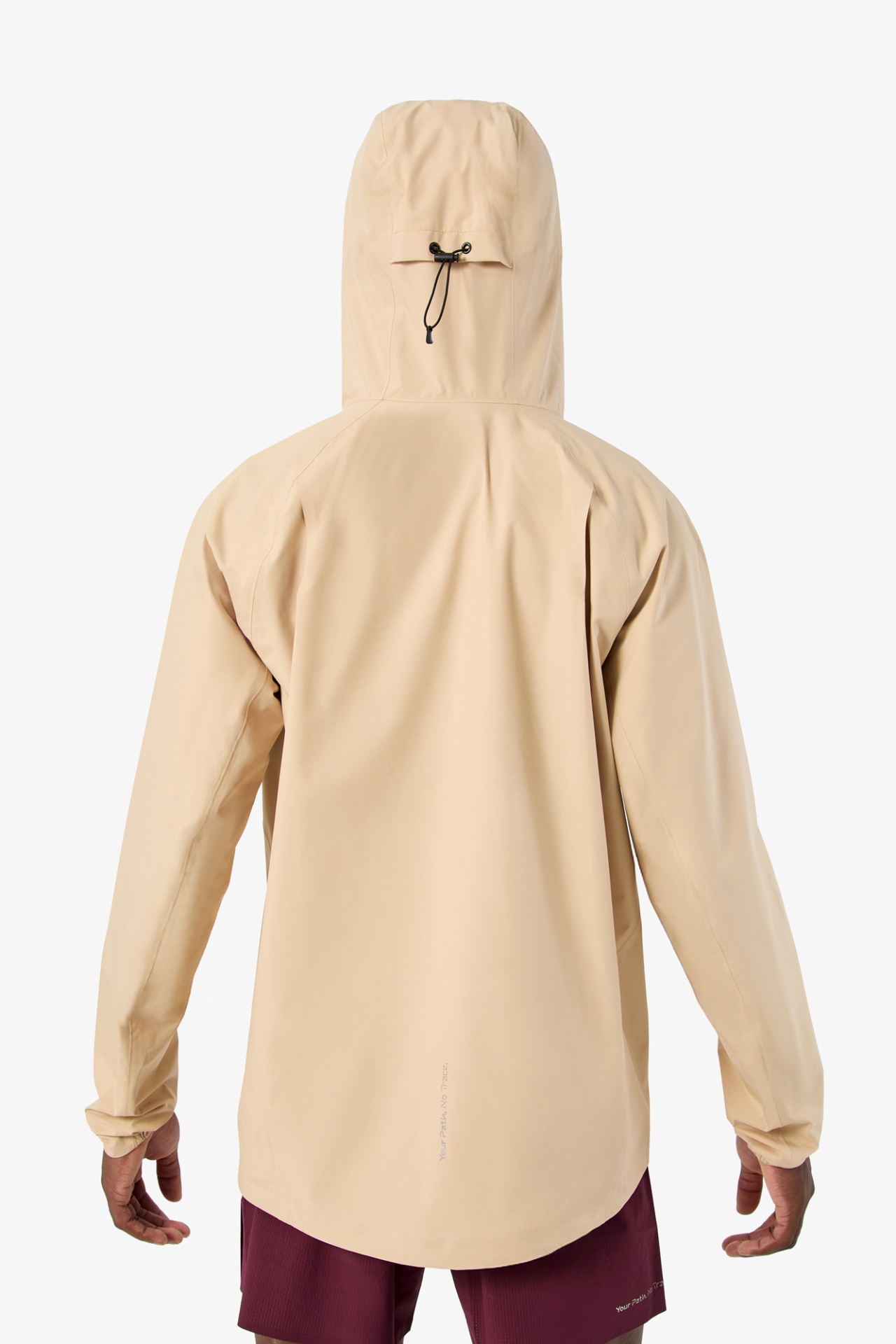 Casaco bege claro com capuz ajustável e texto na parte inferior das costas