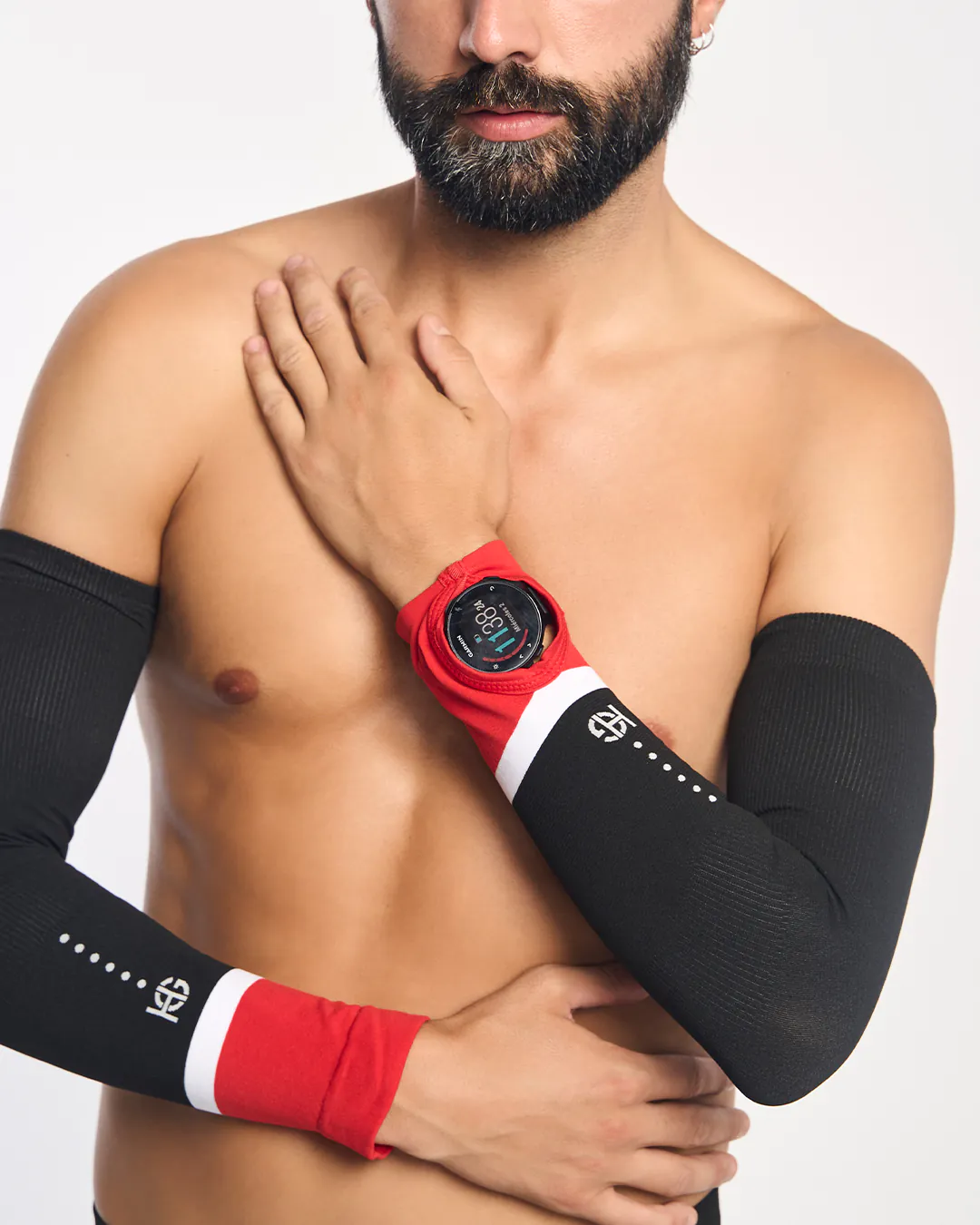Homem com mangas desportivas pretas e vermelhas e relógio inteligente Garmin.