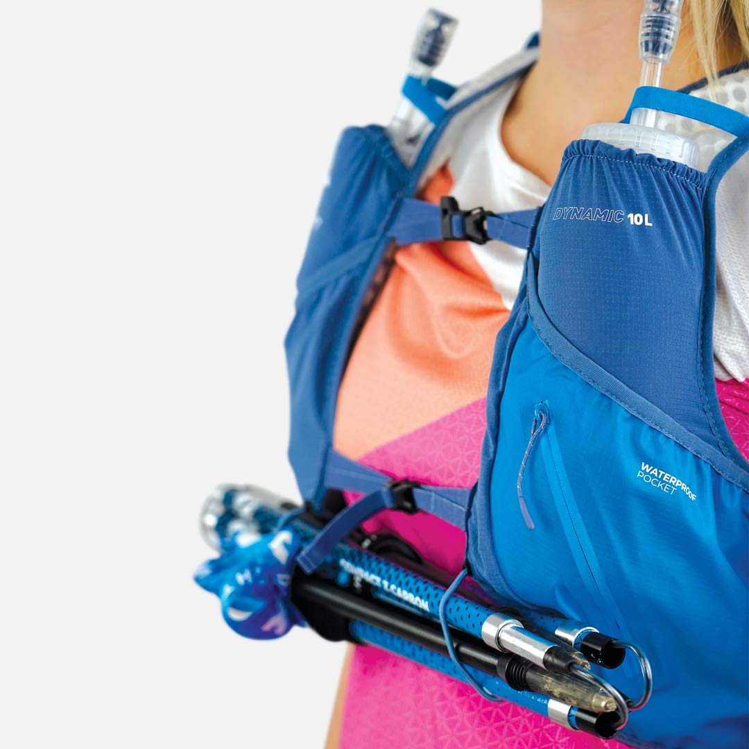 Colete de hidratação azul com bolsos impermeáveis e bastões de caminhada