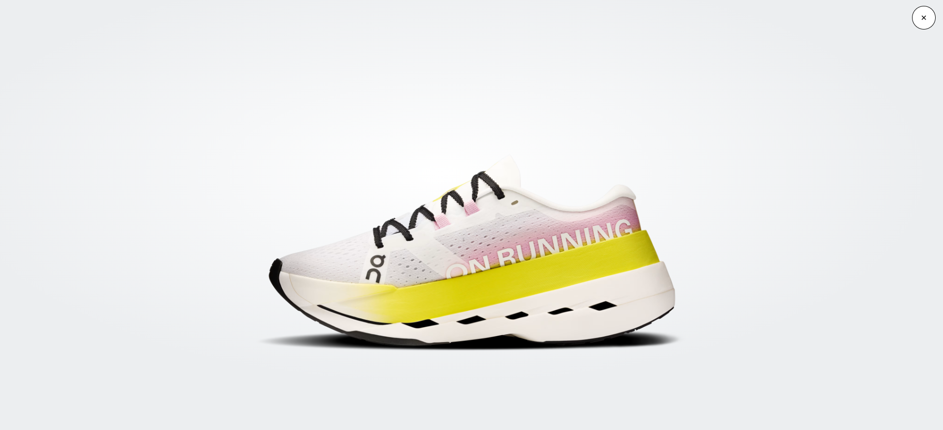 Sapatilha desportiva branca, rosa, amarela e preta com inscrição ON RUNNING.