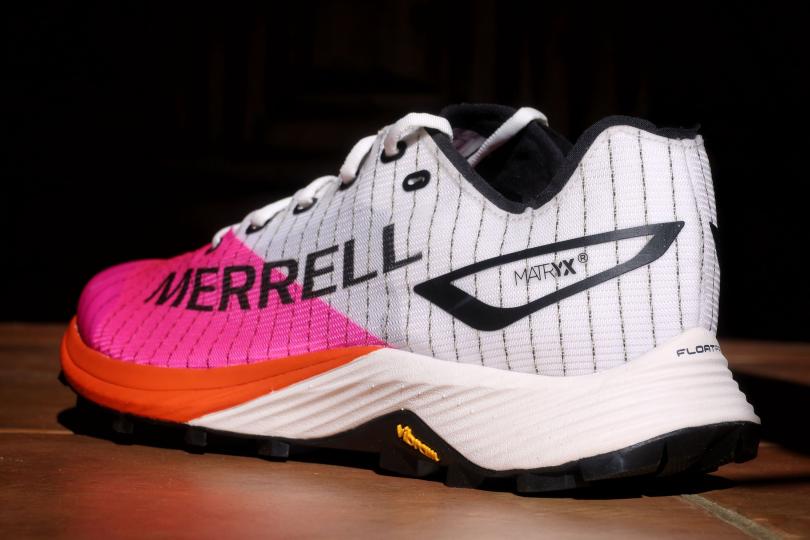Tênis de corrida Merrell rosa e branco com riscas pretas e sola laranja