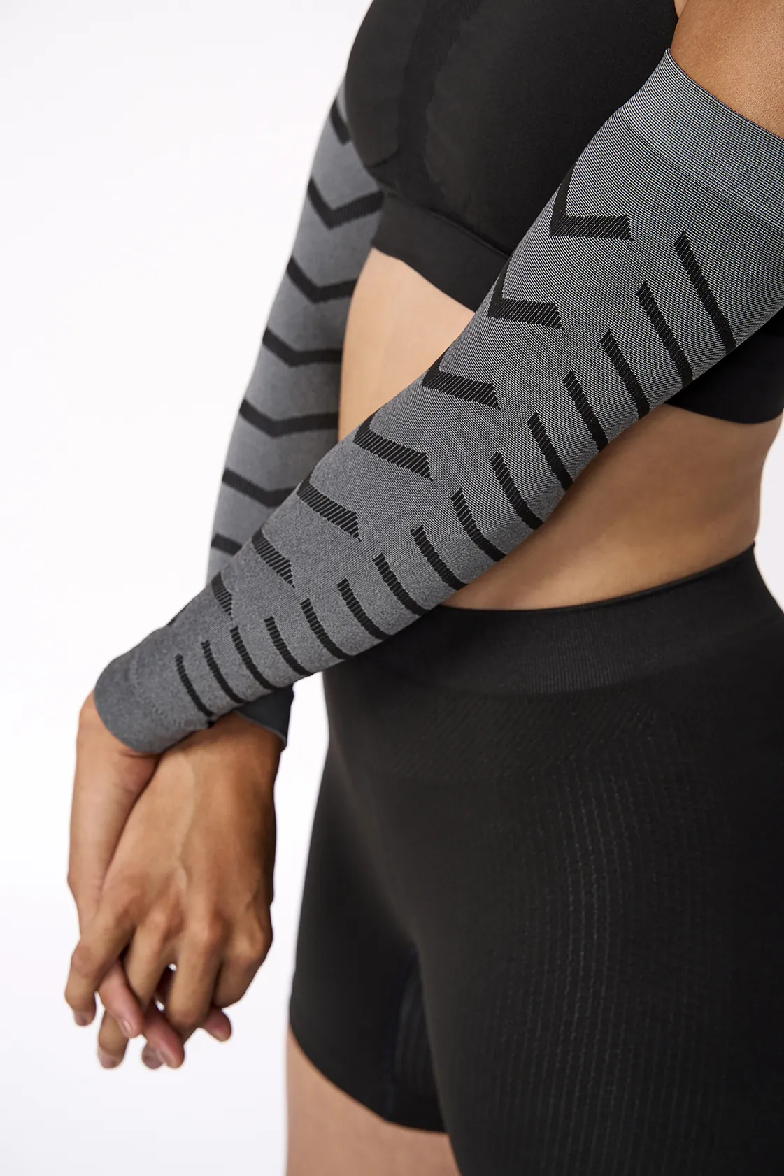 Mangas compressoras cinza com padrão preto usadas com roupa preta
