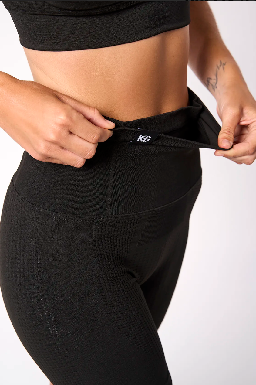 Calças de treino pretas de cintura alta com cordão ajustável usadas por pessoa