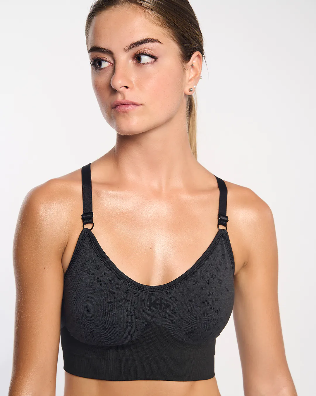 Top desportivo preto com alças ajustáveis e padrão de bolinhas