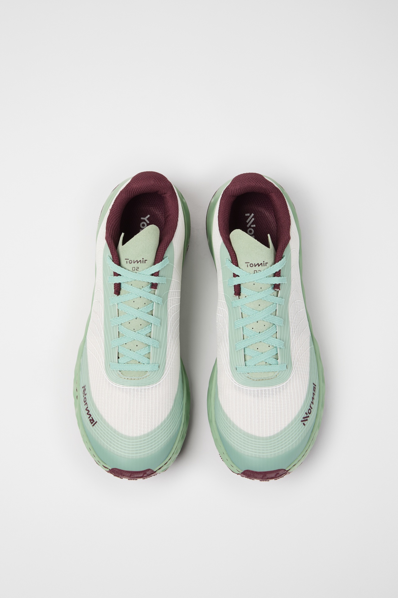 Par de ténis verdes claros, brancos e bordô vistos de cima